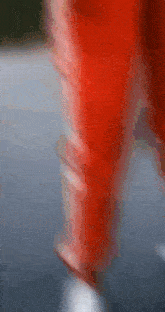 a blurry picture of a person wearing red pants and white shoes