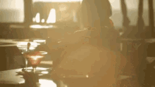 a woman is sitting at a table with a martini glass on it