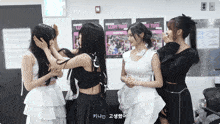 a group of girls are standing in front of a wall with posters that say love tube