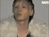 a man in a fur coat is dancing in front of a daze logo