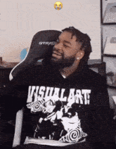 a man wearing a hoodie that says visual art is smiling