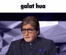 a man with glasses and a beard is sitting in front of a screen with the word galat hua on it