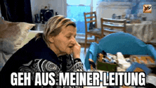 a woman is sitting in a living room with her hand on her nose and the words geh aus meiner leitung written above her .
