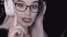 a woman wearing glasses and headphones is making a funny face .
