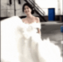 a woman in a white wedding dress is standing in front of a blue door .