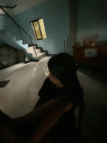 a person sitting in a dark room with a window