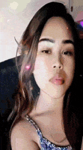 a close up of a woman 's face with long hair looking at the camera .
