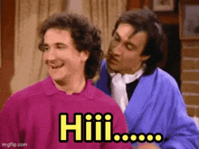 a couple of men are standing next to each other and one of them is saying hiii .