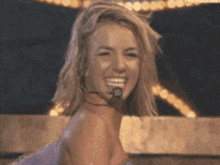 a woman wearing a microphone on her neck is smiling
