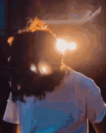 a person holding a candle in front of their face in a dark room