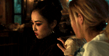 two women are sitting next to each other and one is wearing a black top