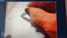 a close up of a person 's hand holding an eraser on a piece of paper
