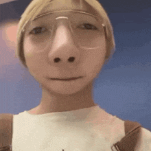 a close up of a person wearing glasses and a white t-shirt