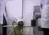 a person in a lab coat is standing next to a model plane