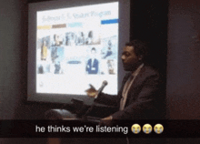 a man giving a presentation with the words he thinks we 're listening behind him