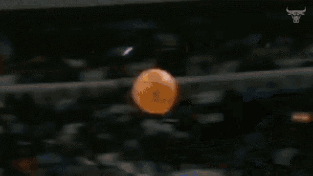 a basketball player is holding a basketball in his hands while dribbling it .