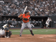 a baseball player getting ready to swing at a pitch with a crowd watching