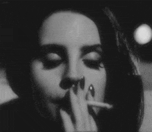 a close up of a woman smoking a cigarette .