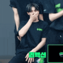 a man wearing a black t-shirt with green letters on it