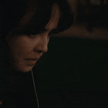 a close up of a woman smoking a cigarette in a dark room .