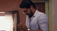 a man with glasses and a beard is praying