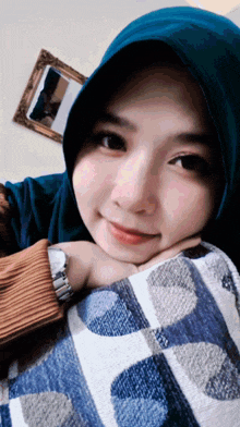 a woman wearing a blue hijab and a watch