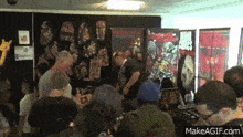 a group of people are gathered in a room with posters on the wall including one that says ' spawn ' on it