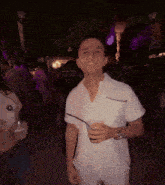 a man in a white shirt is holding a cup and smiling at the camera