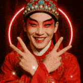 a man in a red costume is making a peace sign with his fingers