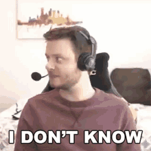a man wearing headphones and a microphone is sitting on a bed and says `` i don 't know '' .