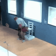 a man is standing next to a white chair in a museum