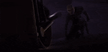 a pixelated image of a man kneeling down in front of a motorcycle