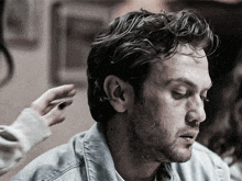 a close up of a man 's face with a woman 's hand on it