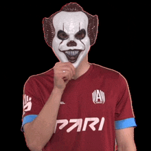 a man wearing a clown mask is wearing a pari shirt