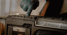 a person is pressing a button on a radio that says ' fm ' on it