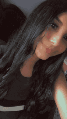 a woman with long black hair is smiling for a selfie