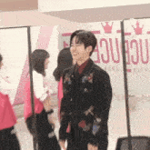 a man in a black jacket is smiling in front of a sign that says " sequence "
