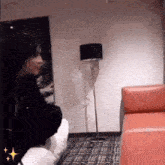 a person sitting on a couch in a living room with a lamp