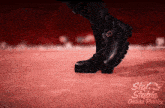 a person wearing a pair of black boots with the words star stable online polska on the bottom right