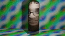 a man 's face is visible through a hole in a wall