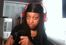 a woman with dreadlocks wearing headphones holds a camera