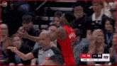 a basketball player with the number 9 on his jersey talks to a referee during a game