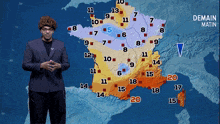 a man in a suit stands in front of a map of france that says demande matin