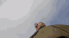 a man is standing in front of a cloudy sky looking up at the sky .