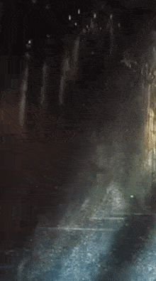 a person is walking through a dark tunnel in the rain .