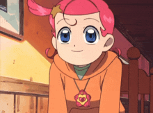 a girl with pink hair and blue eyes is wearing an orange sweatshirt
