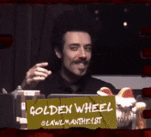 a man with a sign that says golden wheel