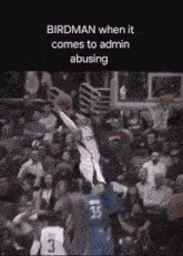 a basketball player is jumping in the air during a game while a crowd watches .