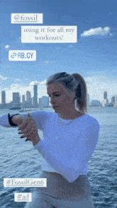 a woman wearing a white shirt and tan pants is using a smart watch