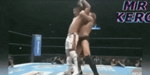 two men are wrestling in a ring with the words mr. kerc written on the bottom of the screen .